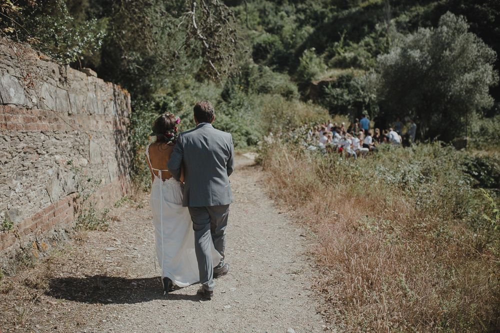 Couple walking together on a dirt path surrounded by nature.