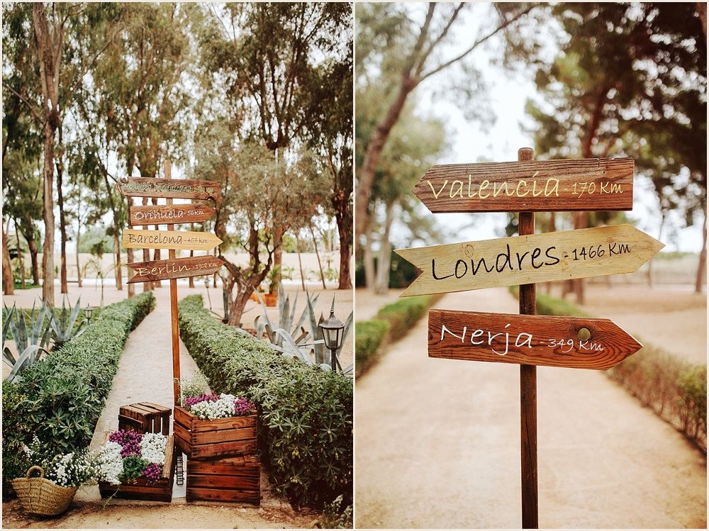 Rustic wooden wedding directional signs in an outdoor garden setting.