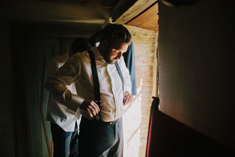 Sunlight streams through doorway highlighting a formal suit and tie preparation moment.