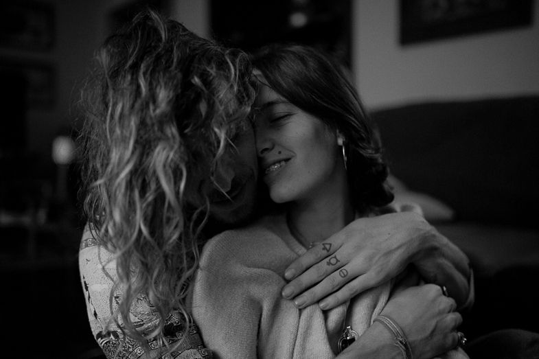 Black and white photo showing tender embrace in a cozy home setting.