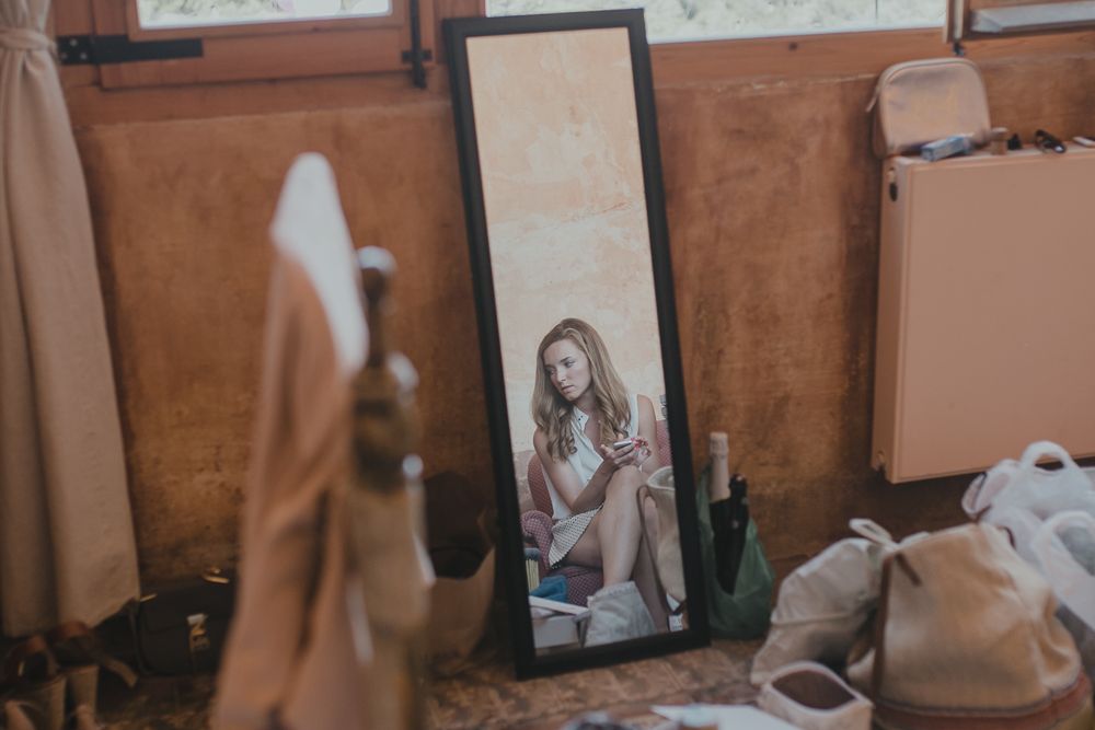 Artistic mirror reflection shot in a room with brown walls and scattered items on the floor.