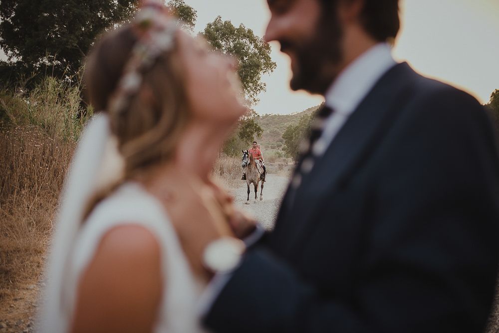 Intimate wedding moment captured in soft focus against a natural outdoor backdrop.