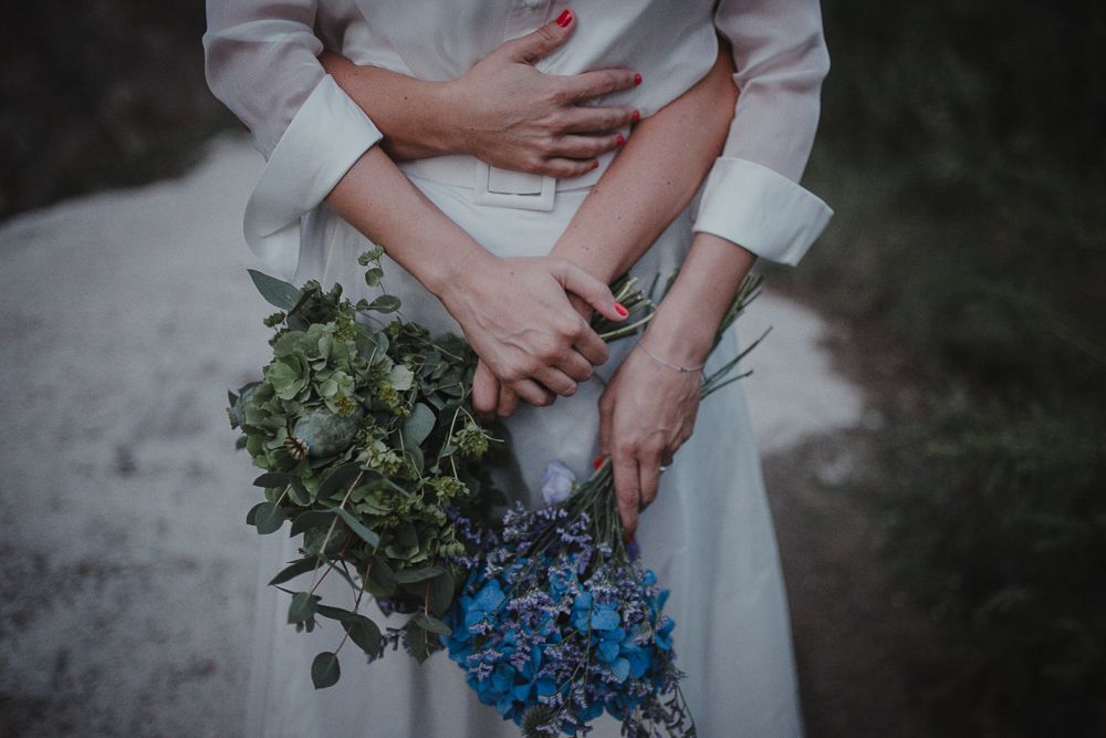 Wedding attire detail shot with blue hydrangea bouquet and eucalyptus greenery.
