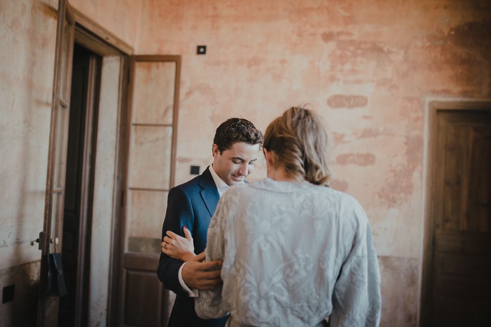 Two people sharing moment in bright corner room with vintage pink walls.