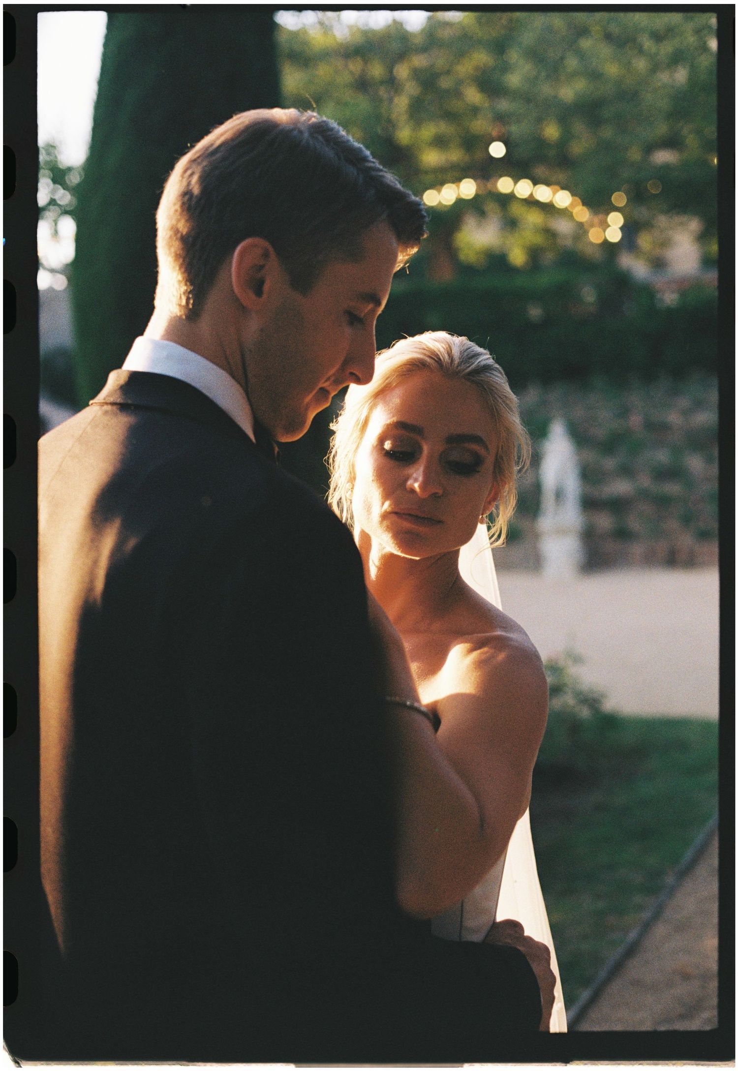 Intimate portrait of couple in golden hour lighting at garden wedding.