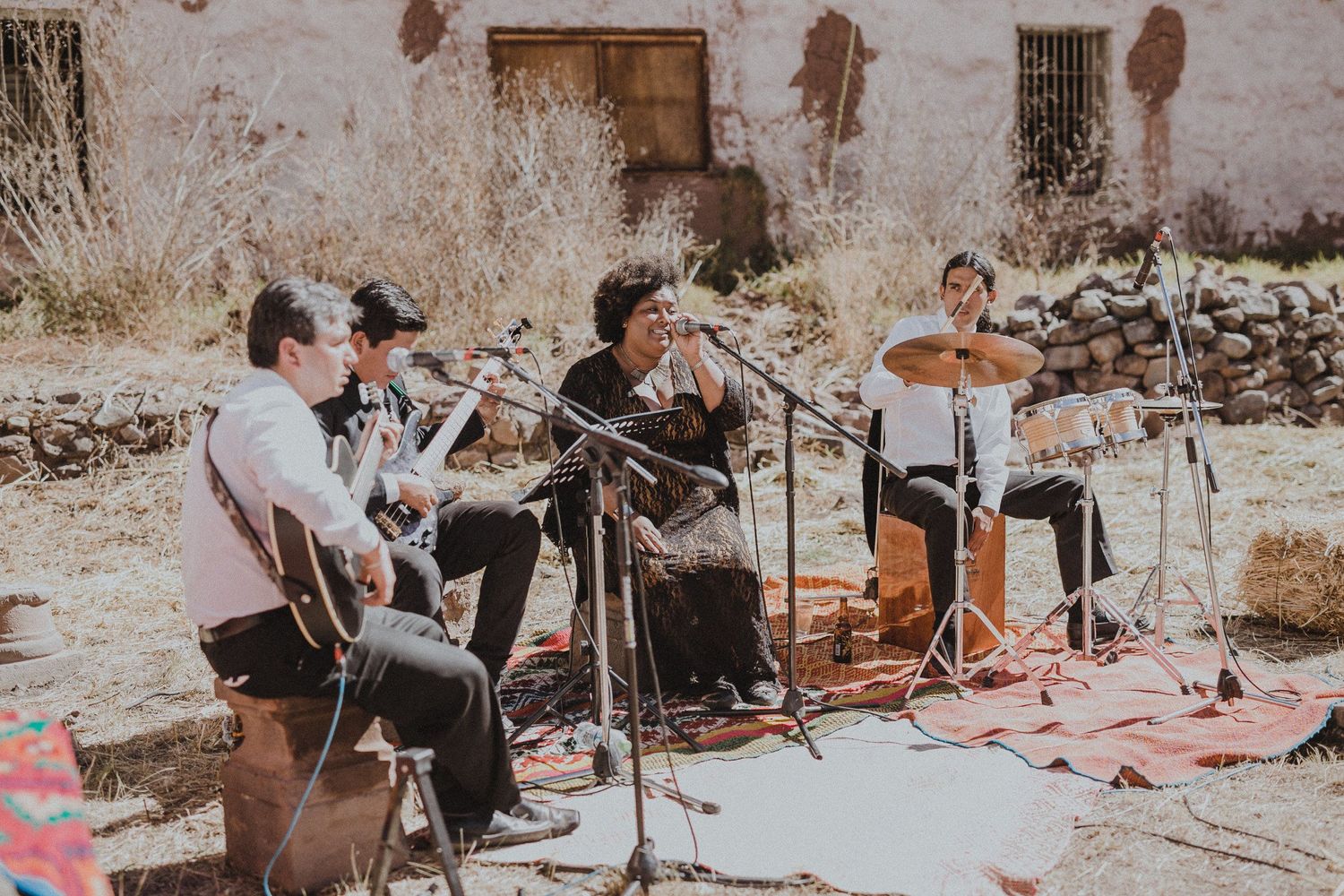 A live band performs with acoustic instruments at an outdoor desert venue.