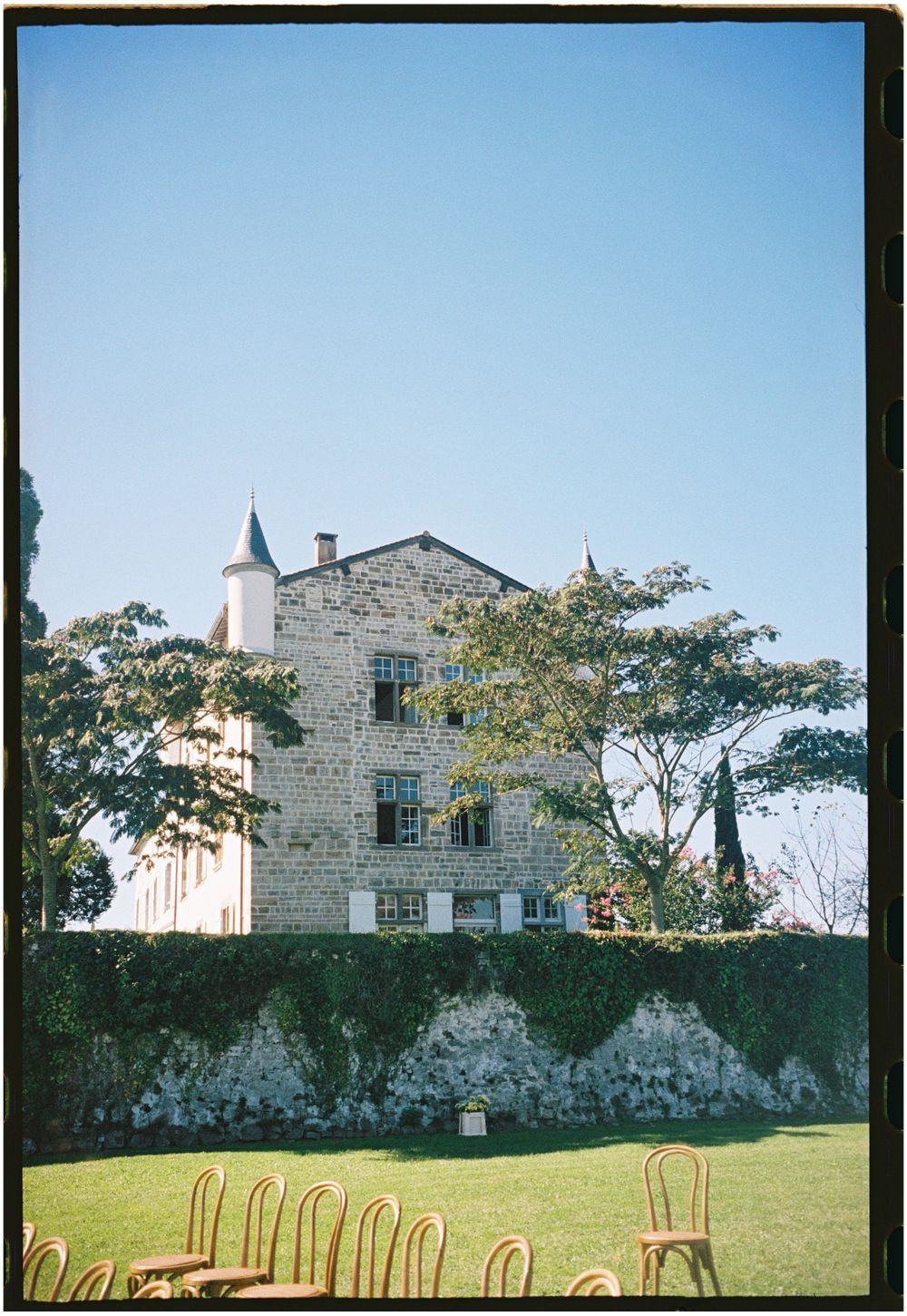 Stone chateau venue with chairs set up on lawn for outdoor ceremony.