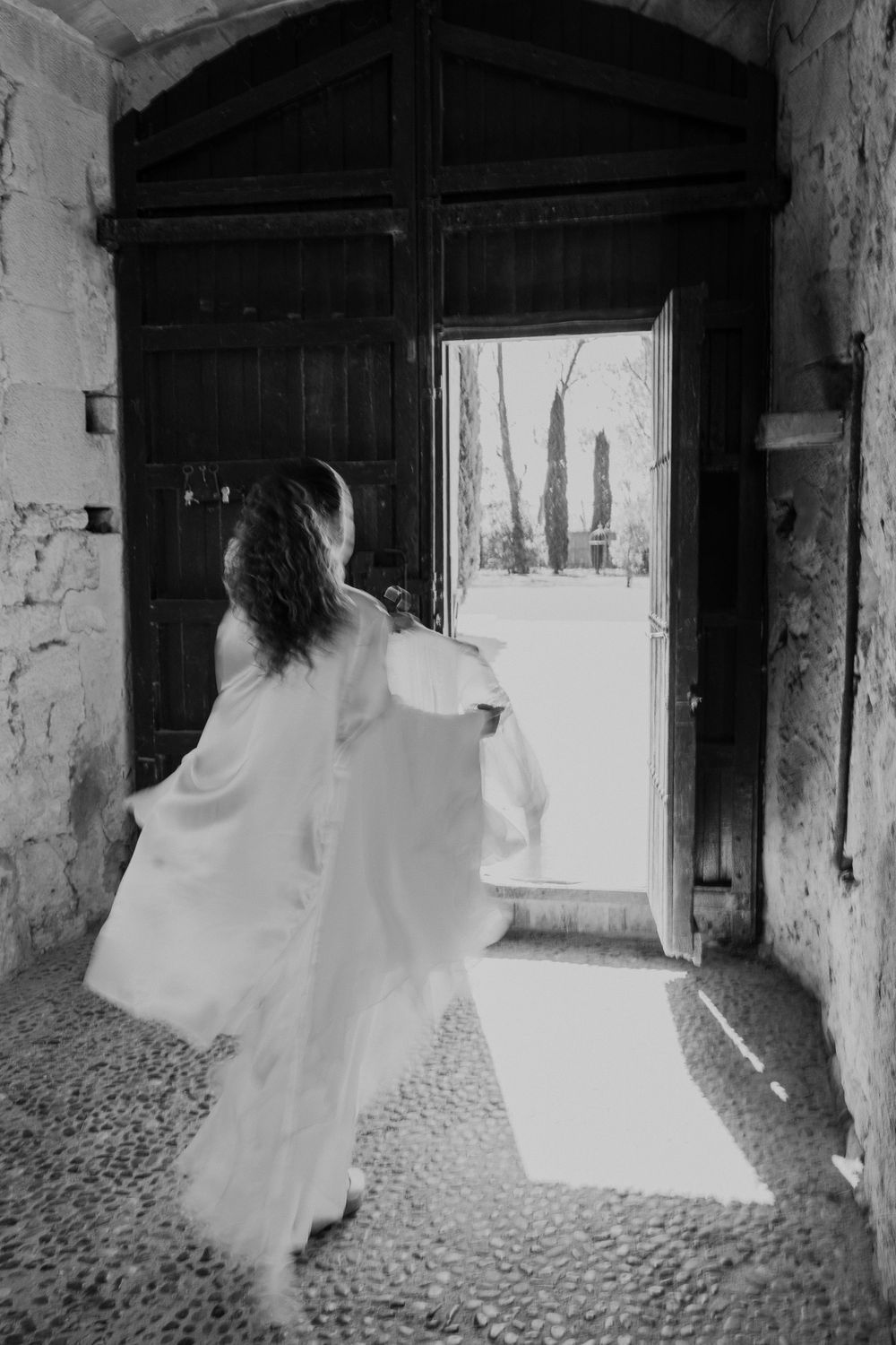 Artistic black and white photos capture movement in a historic stone corridor.