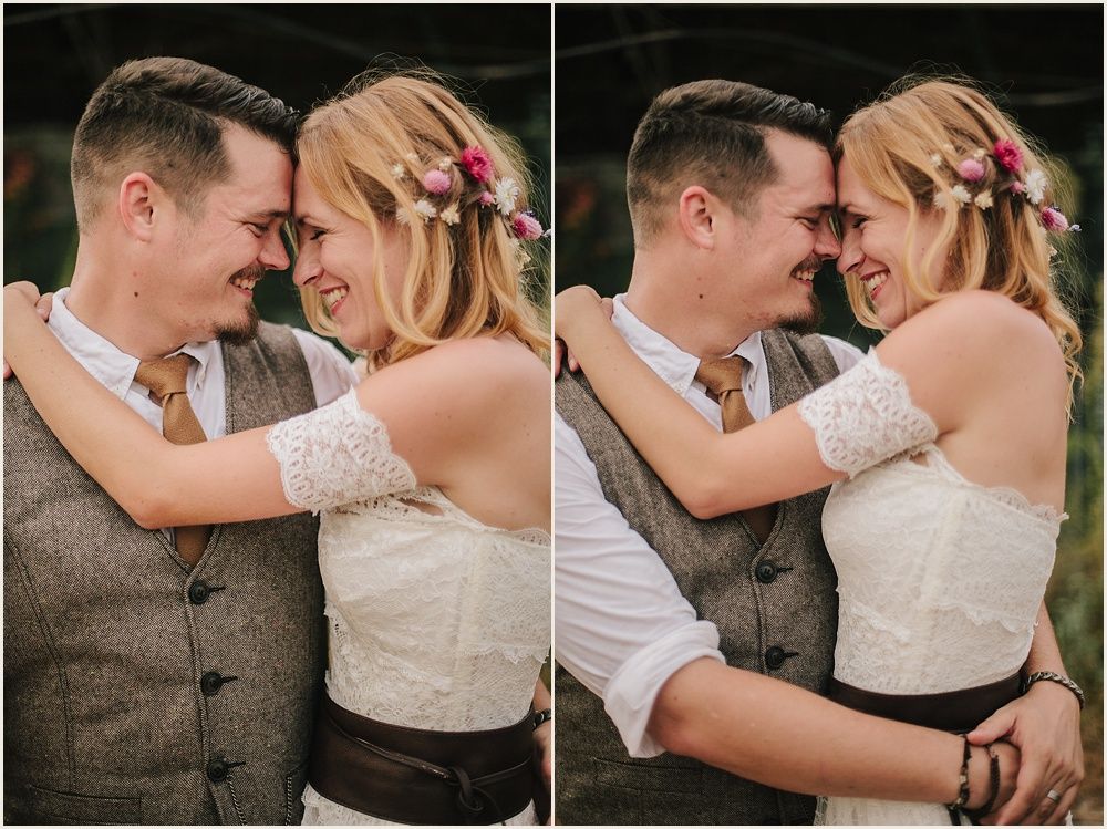 Intimate moment captured between couple in rustic wedding attire.