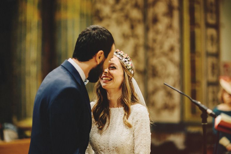 A tender moment between newlyweds during their church ceremony with warm lighting.