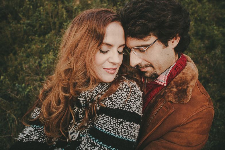 Intimate portrait of couple in winter sweaters sharing a tender moment outdoors.