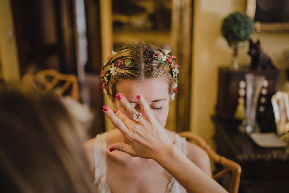 Close-up shot of bridal makeup application in warm indoor lighting.