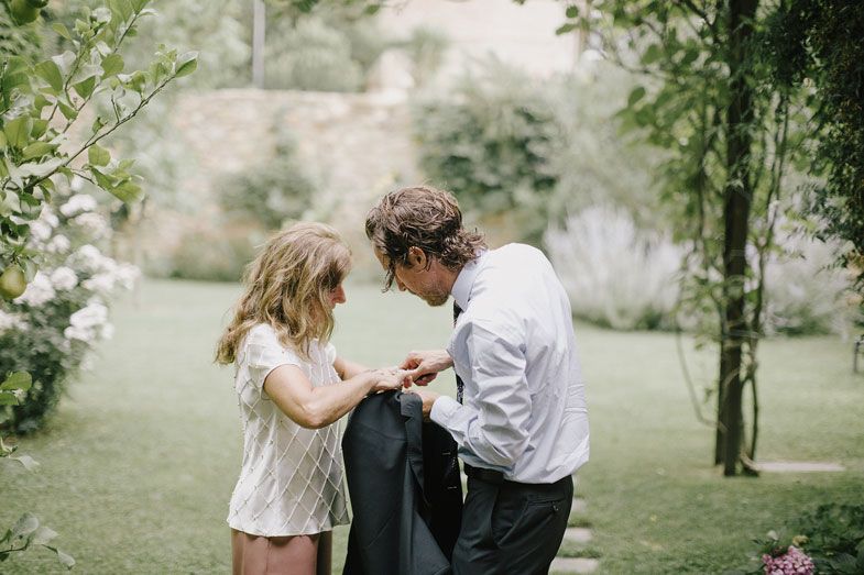 Two people share an intimate moment in a lush garden setting.