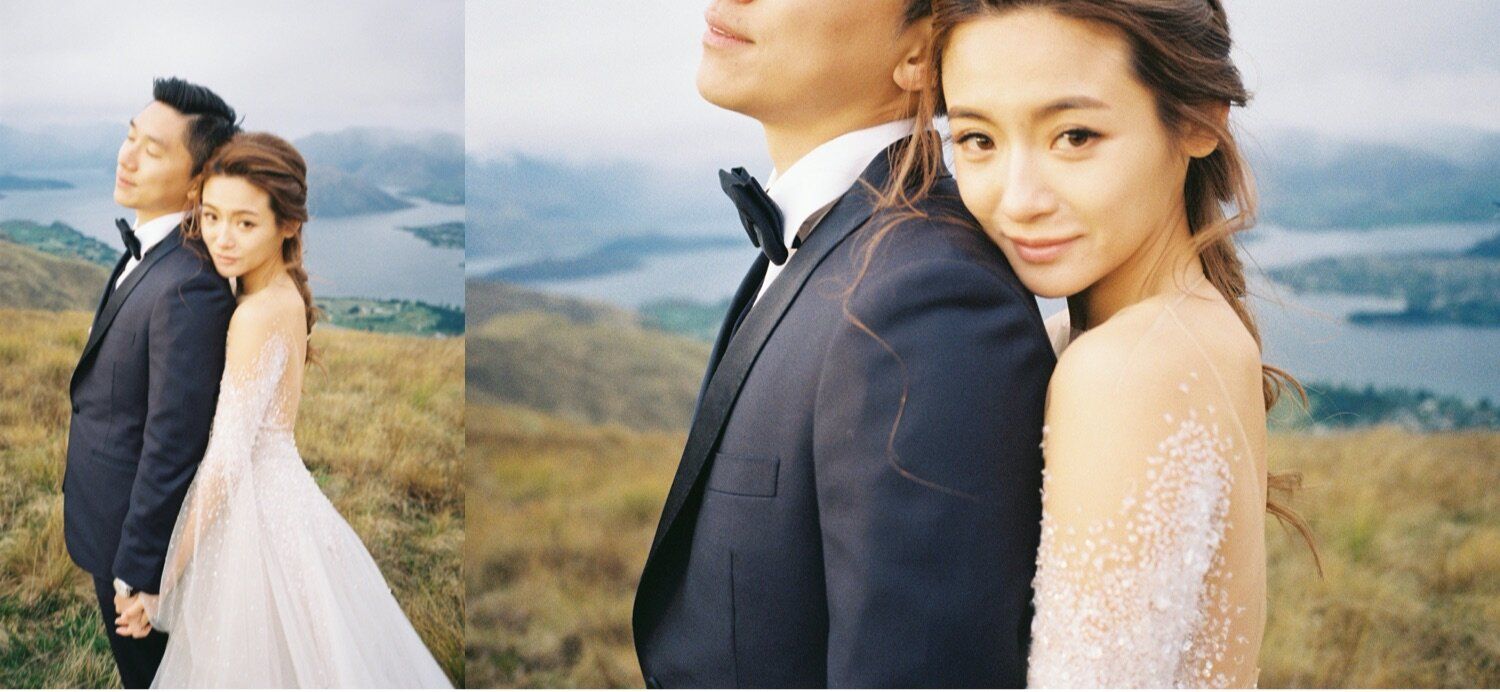 Romantic wedding portraits captured on mountainside with stunning lake vista in background.