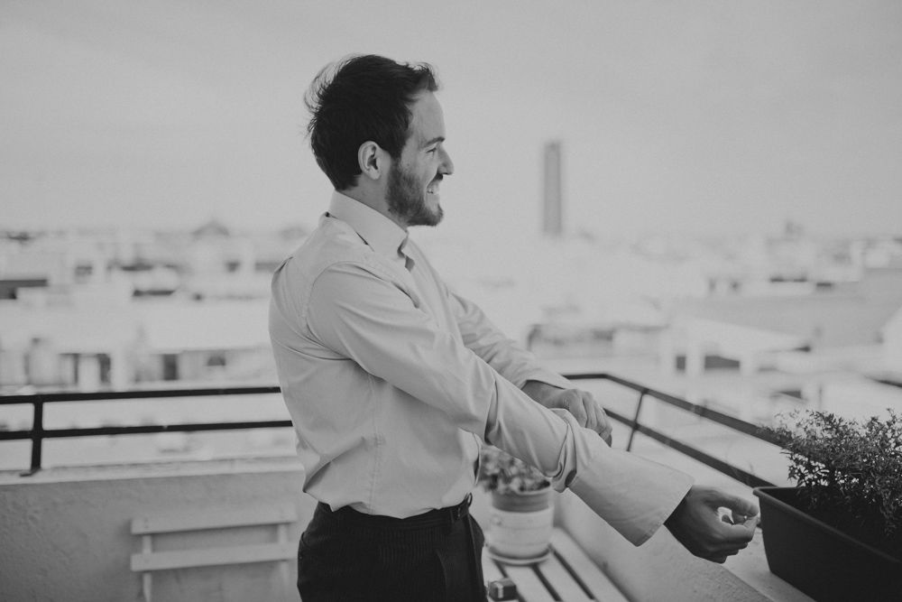 Black and white portrait of a person in dress shirt on an urban balcony.