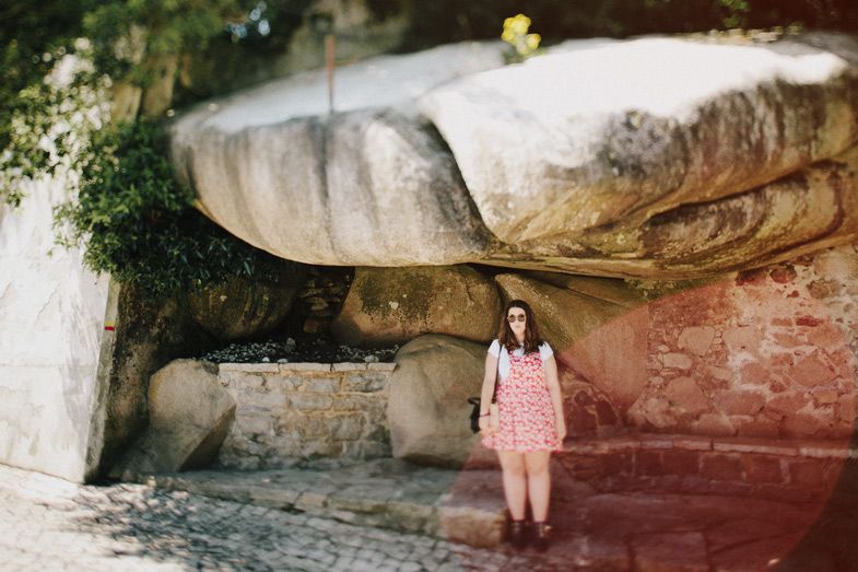 Pink dress contrasts against ancient stone walls and architectural details.