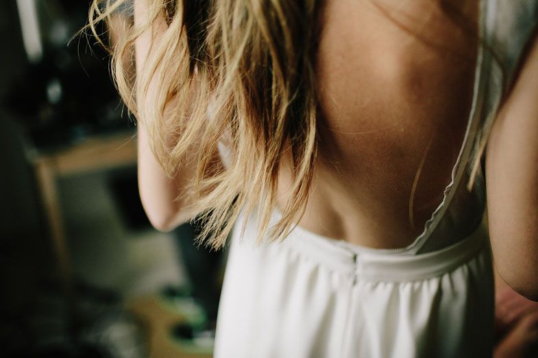 Close-up shot of blonde hair and white clothing strap.