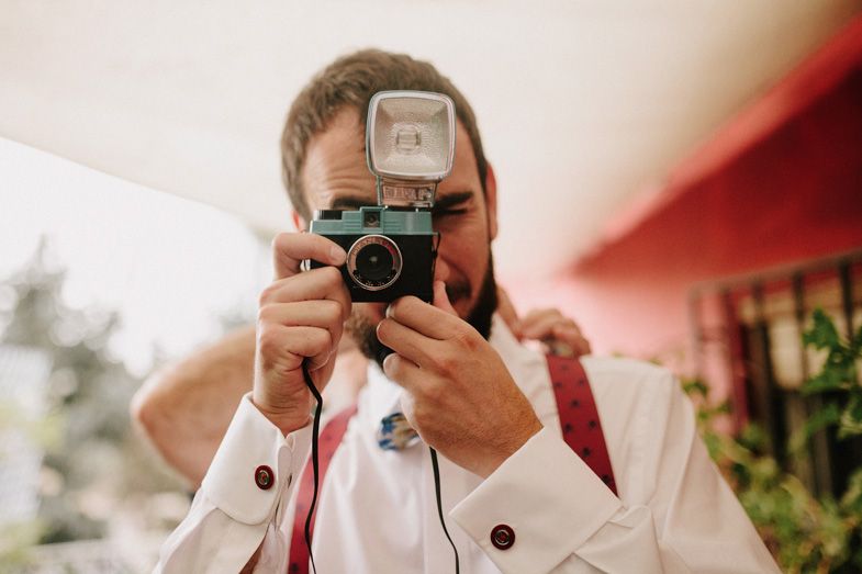 Photographer capturing a moment through a vintage camera lens outdoors.