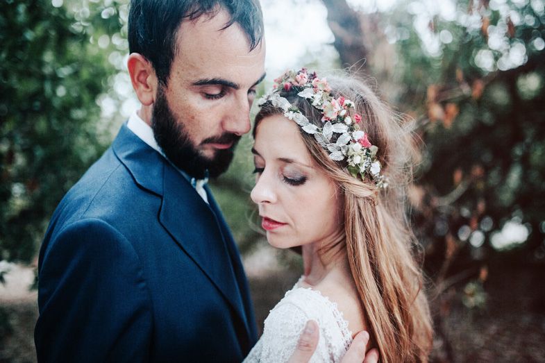 An intimate wedding portrait showing a tender moment between newlyweds in a garden setting.