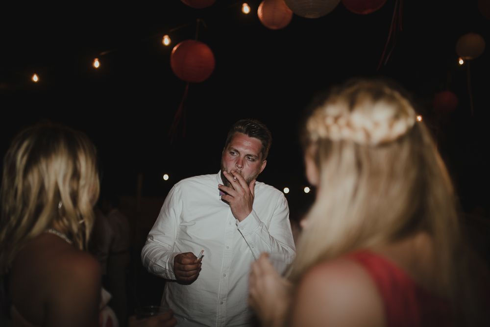 Guest in a floral dress dancing at a dark reception venue.