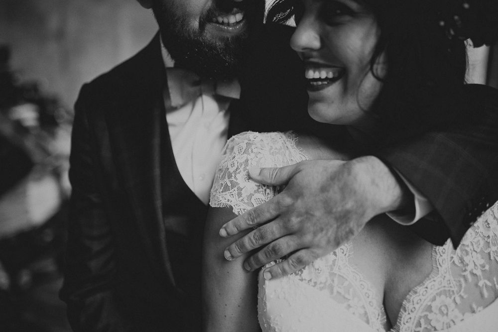 Black and white candid wedding moment showing joy and laughter.