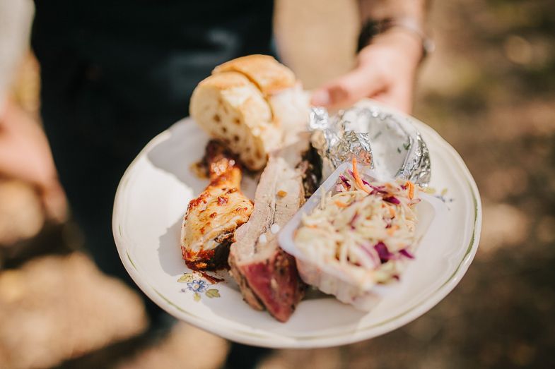 A plate of gourmet appetizers and rolls served at an outdoor wedding reception.