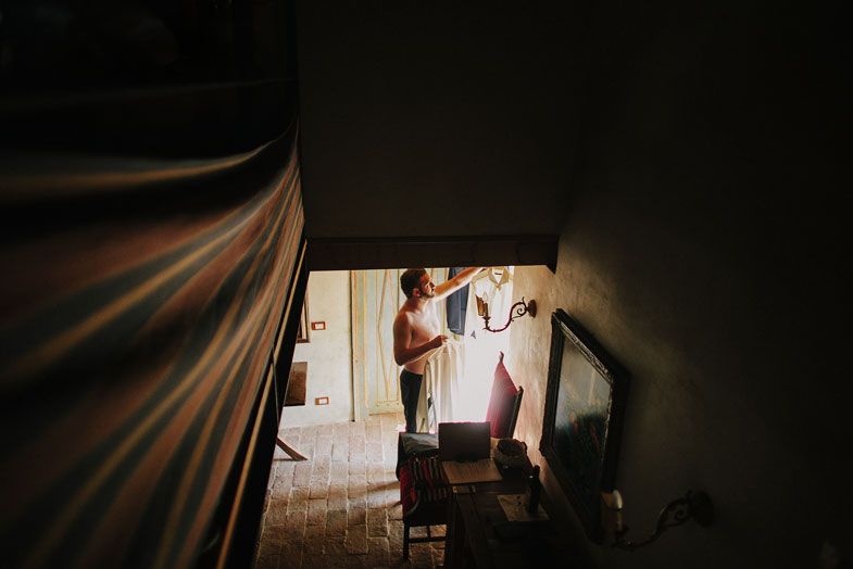 Silhouette getting ready in a dimly lit rustic room with dramatic lighting.