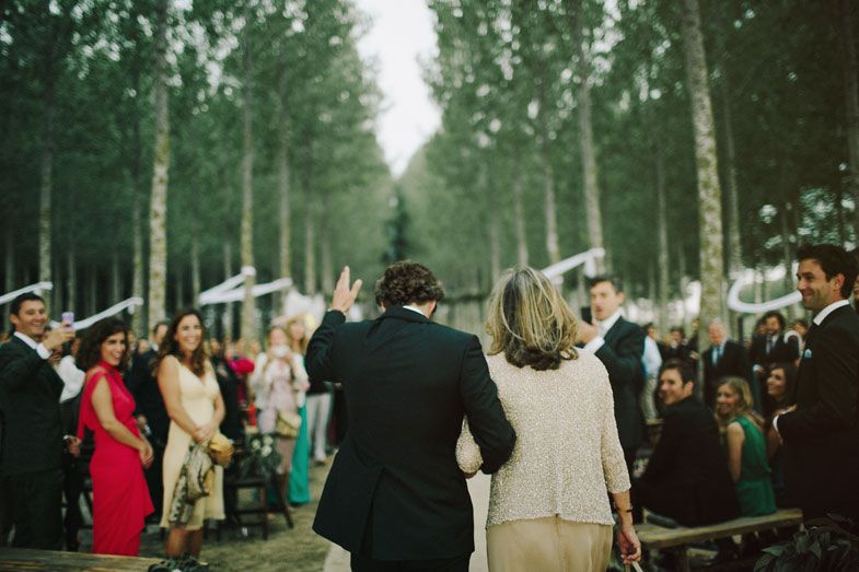 Celebratory moment at an outdoor forest wedding with guests cheering.