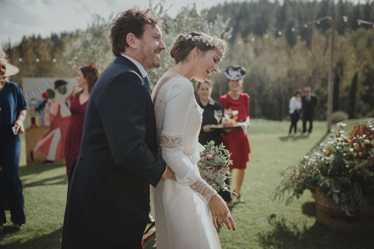 A wedding ceremony taking place on a sunny lawn with mountain scenery in the background.