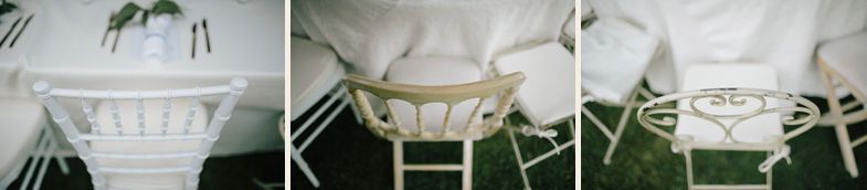 White vintage wedding chairs arranged in a row at an outdoor ceremony venue.
