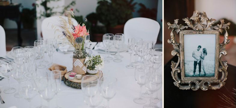 Wedding reception table setting with centerpiece on wood slice and framed photograph.