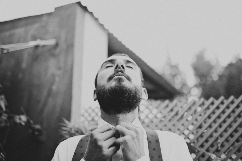 Black and white portrait of formal preparation against white wall and lattice fence.