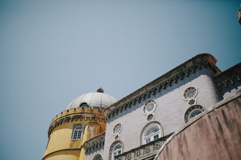 Architectural details of Pena Palace showing domed tower and ornate window designs.