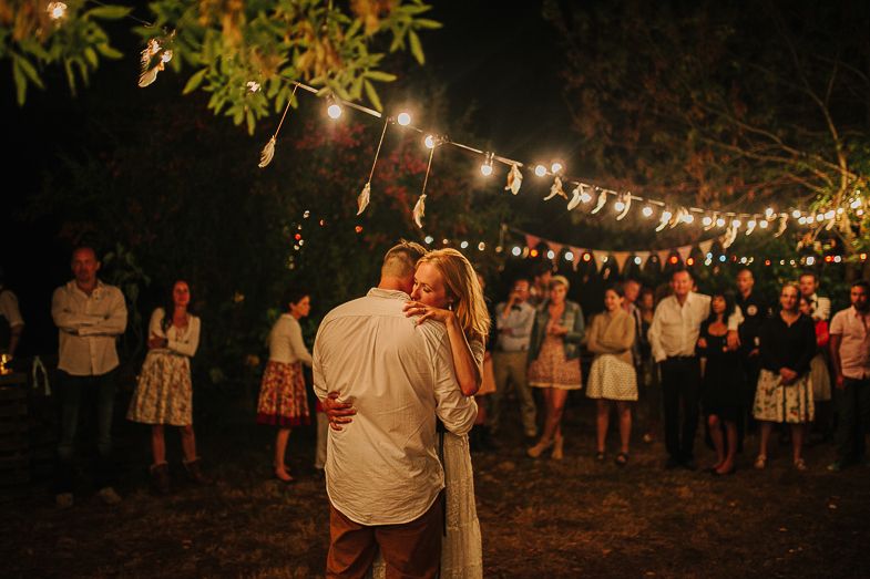 Evening wedding reception with string lights as guests watch the first dance.