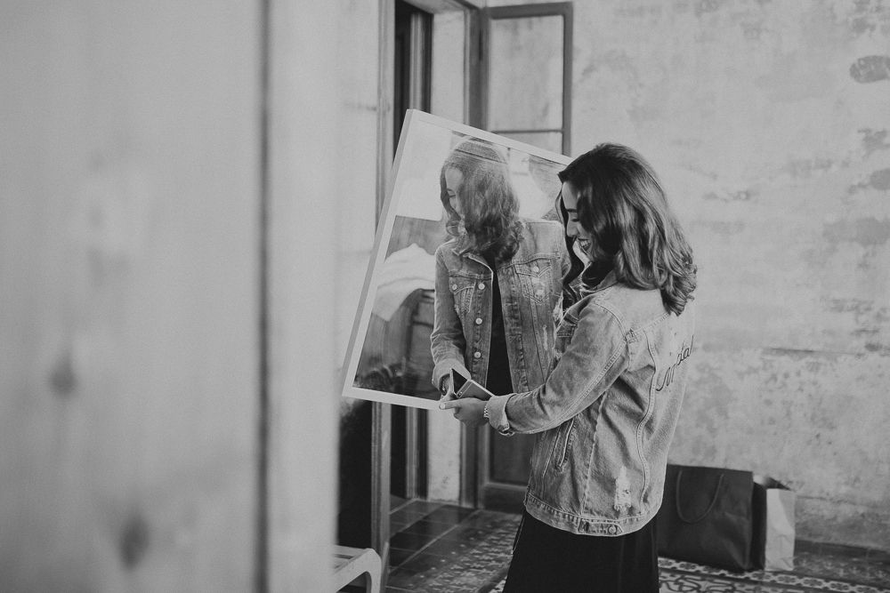 A denim jacket being examined in front of a mirror.