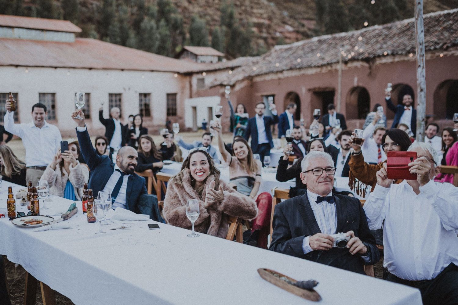 Guests seated at long outdoor tables during a festive celebration event.