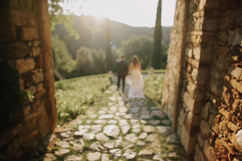 A romantic black and white wedding photo captured under blooming trees.
