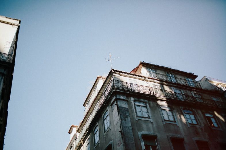 Looking up at traditional Portuguese architecture against blue sky.