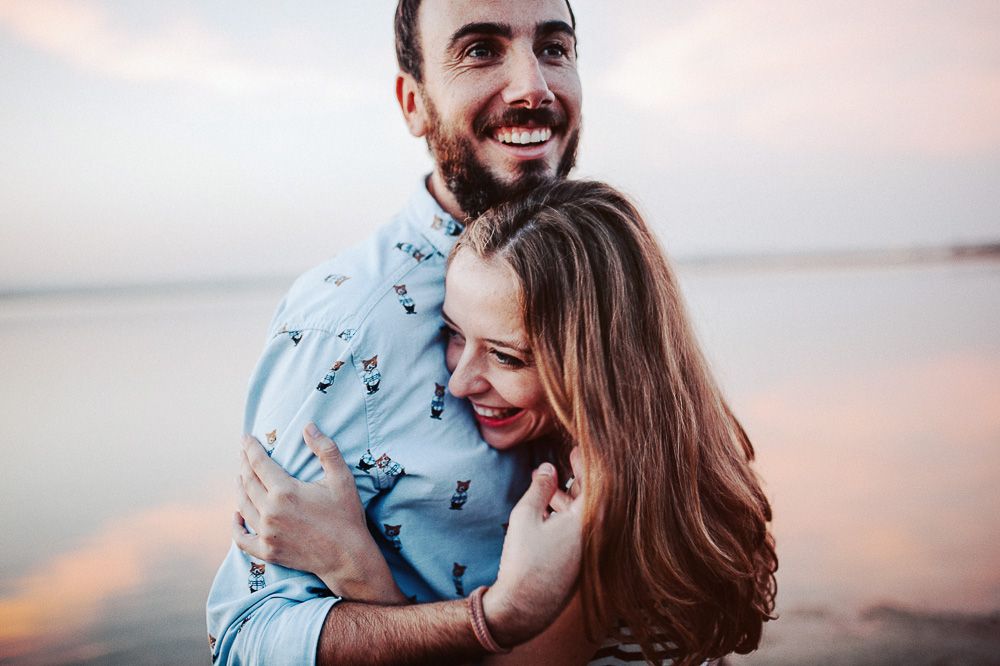 A happy couple shares laughter during their sunset photoshoot.
