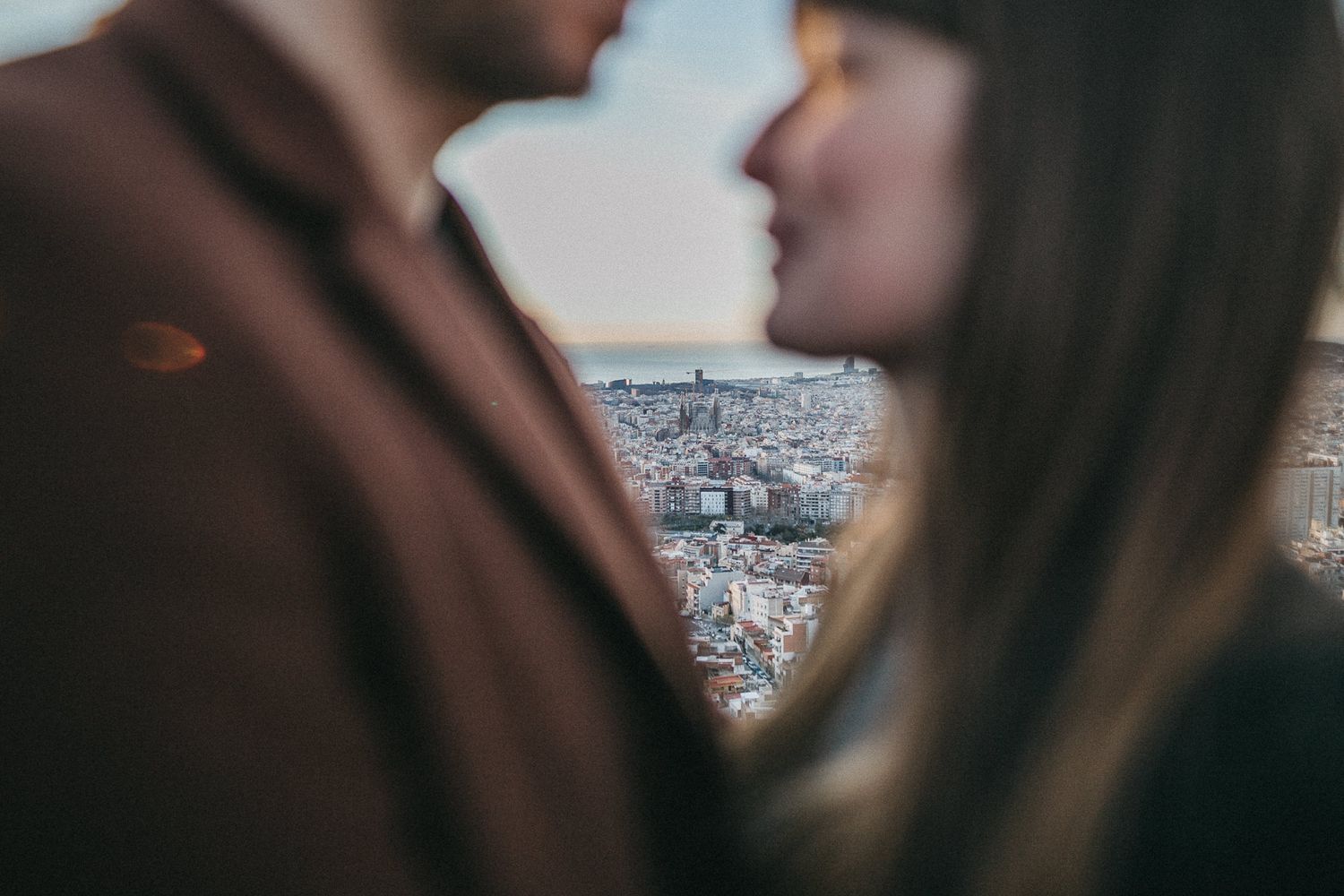 Intimate close up of couple with blurred city backdrop.