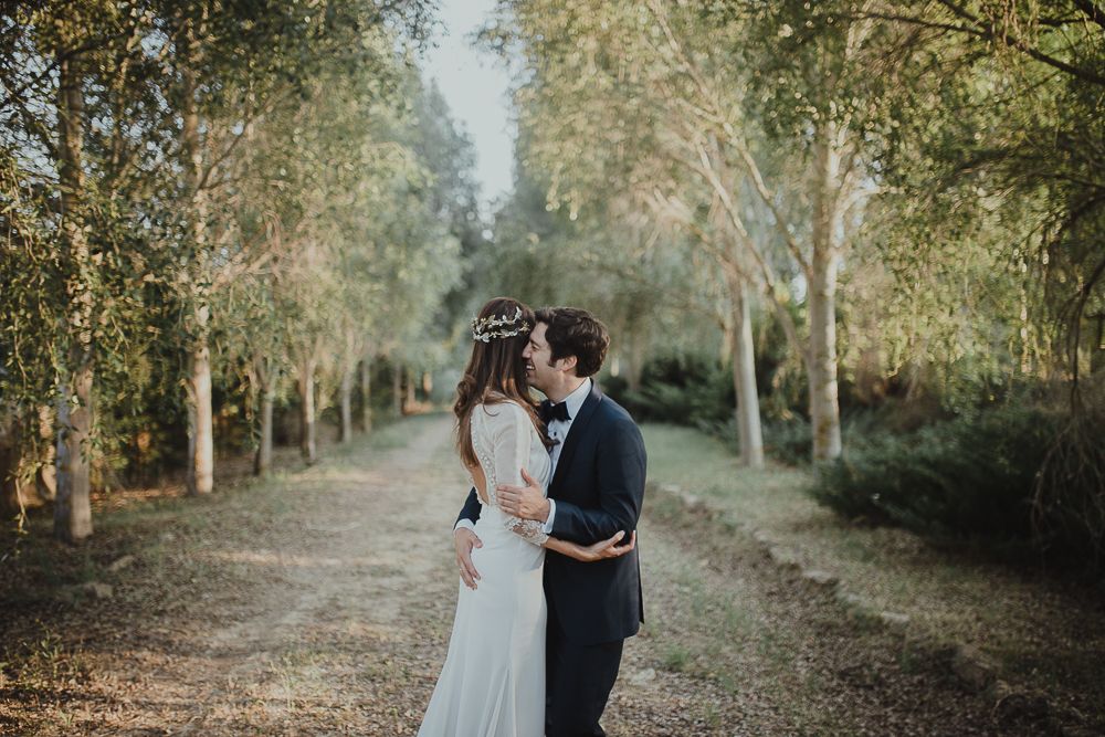 Intimate moment between couple on rustic path surrounded by birch trees.