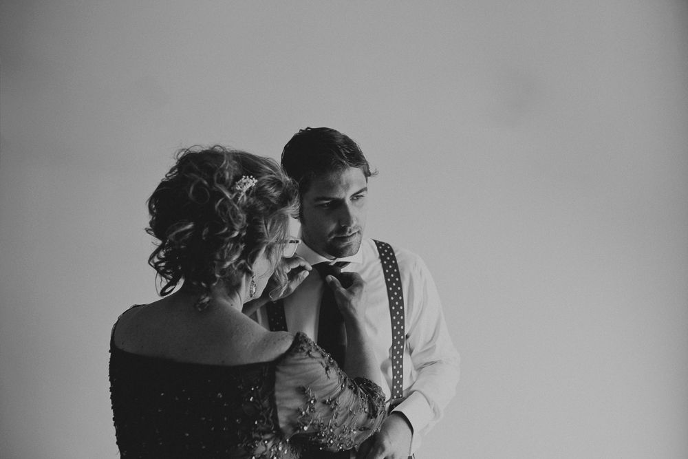 Intimate black and white portrait of formal couple in close embrace.