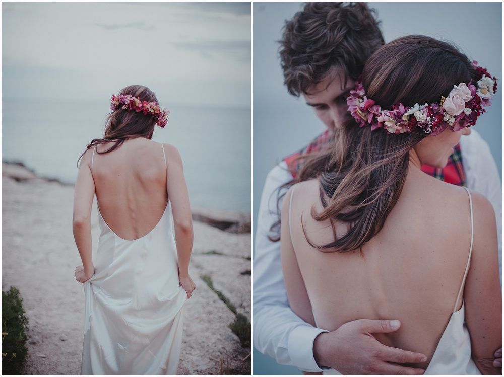 Back view of bride in backless dress with pink floral crown on beach.