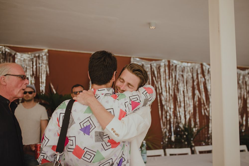 Two people embracing at indoor party with silver streamer decorations.