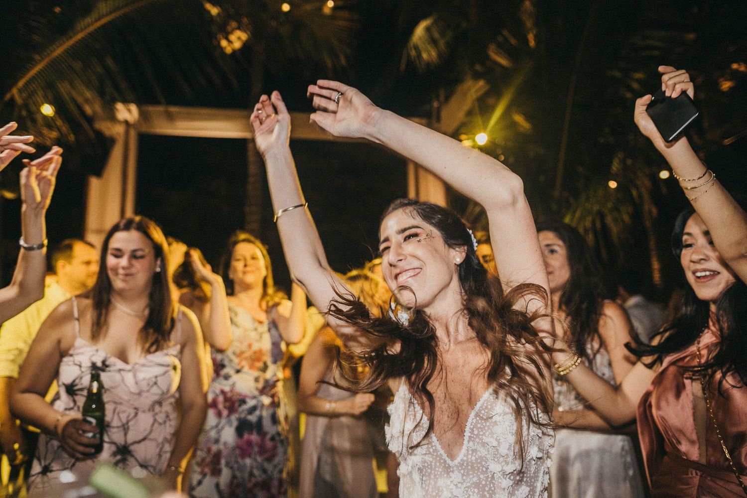 Wedding guests dancing and celebrating at a lively reception party.