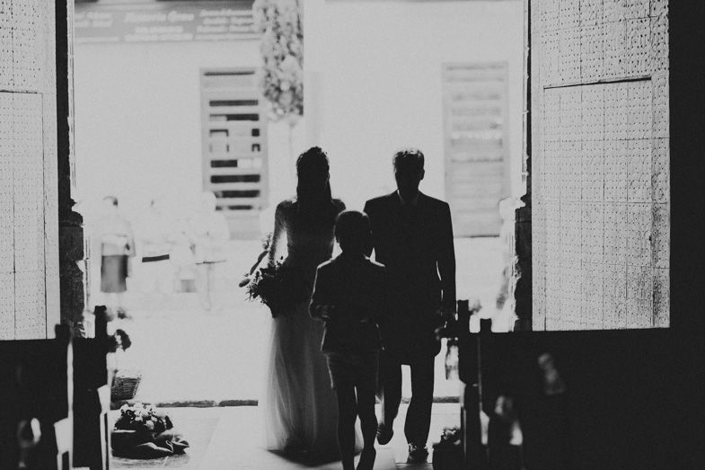 Silhouette of couple walking through bright doorway in dramatic black and white photograph.