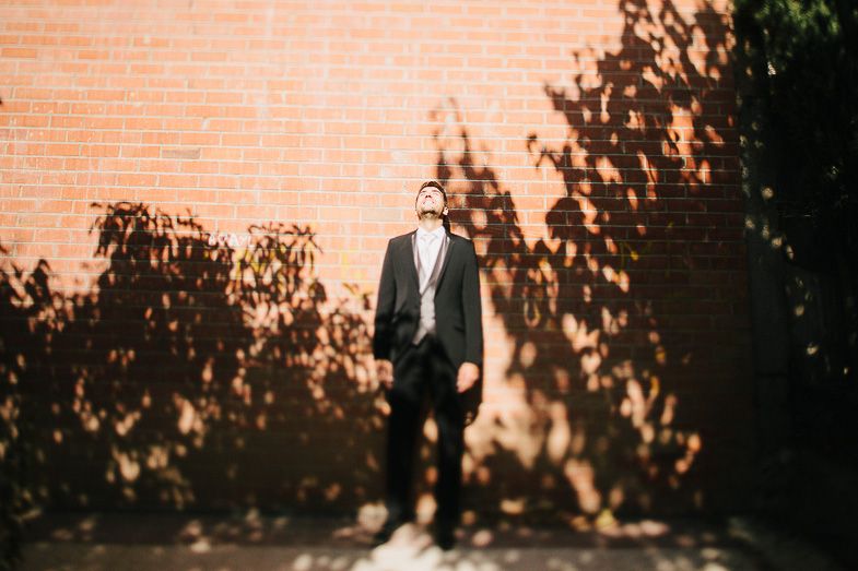 Silhouette against brick wall with dramatic tree shadow patterns.