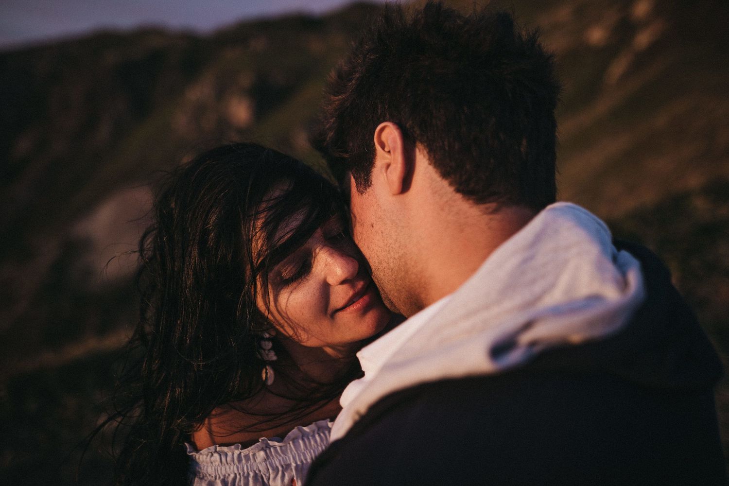 Romantic sunset close-up of a couple sharing an intimate moment in the mountains.