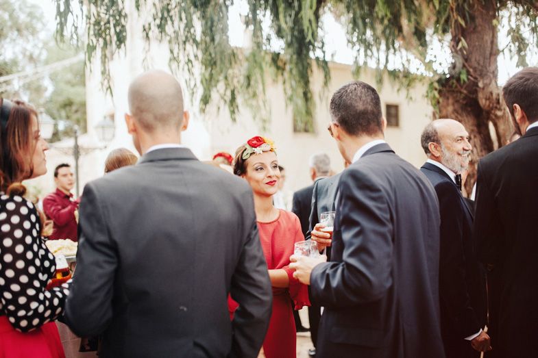 A social gathering of formally dressed guests mingling at an outdoor event.