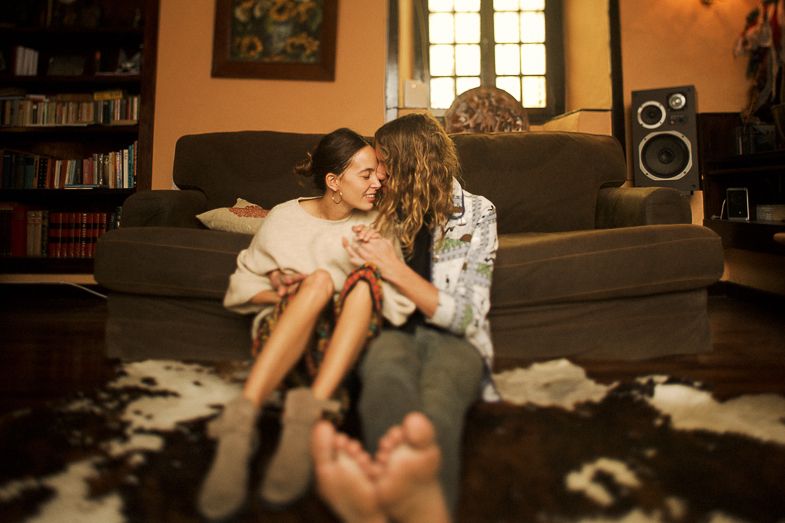 An intimate moment captured in a warm living room with natural window light.